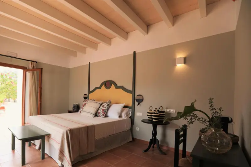 Une chambre lumineuse avec un grand lit à baldaquin et une plante verte.