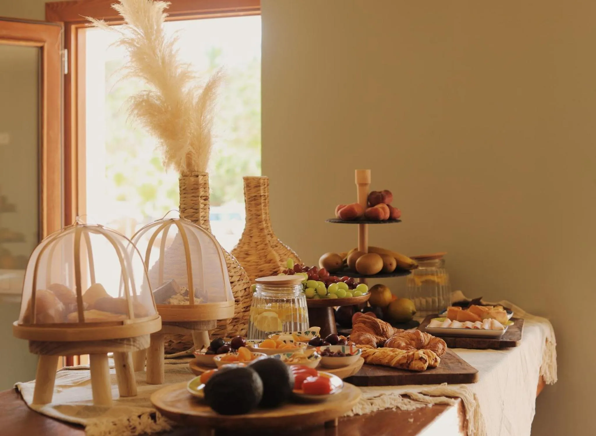 Une table est dressée avec des pâtisseries, des fruits et des viennoiseries.