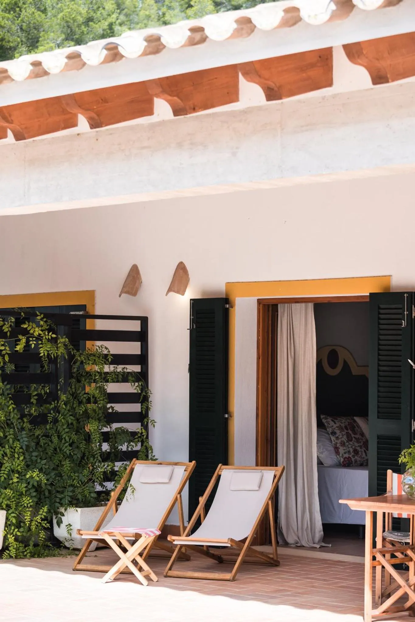 Deux transats blancs sont placés devant une terrasse ombragée.