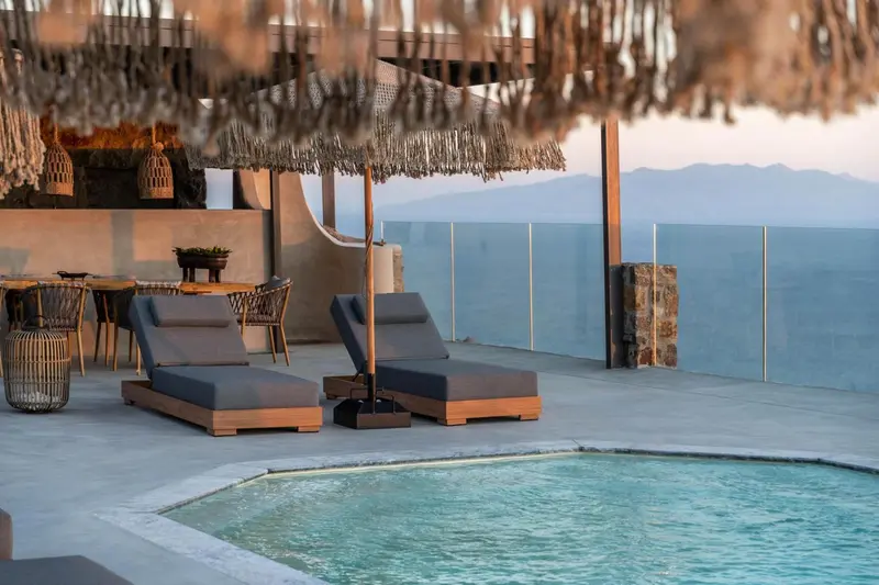 Terrasse aménagée avec chaises longues et petite piscine face à la mer.