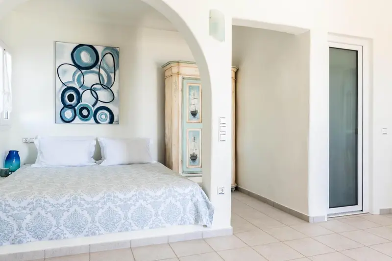 Une chambre lumineuse avec un grand lit et une décoration murale.