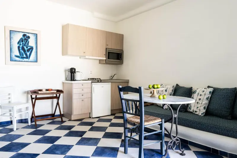 Une kitchenette lumineuse s'ouvre sur un coin repas avec banquette.