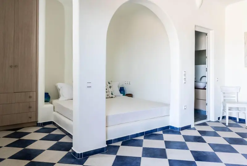 Une chambre lumineuse avec un lit encastré dans une niche.
