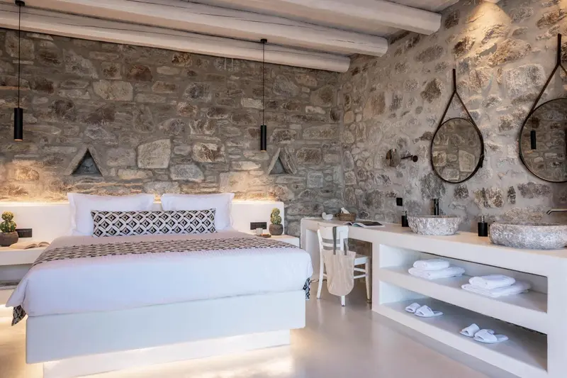 Une chambre lumineuse avec un grand lit et une salle de bain ouverte.