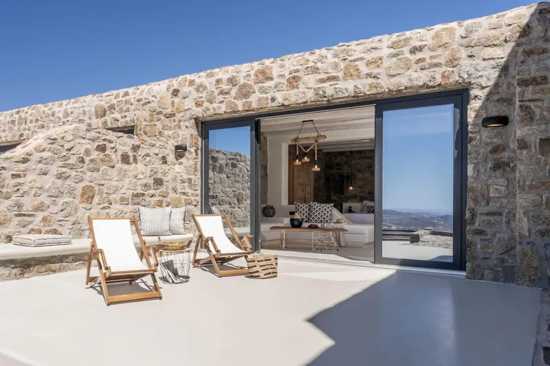 Terrasse aménagée avec chaises longues et vue sur le paysage.