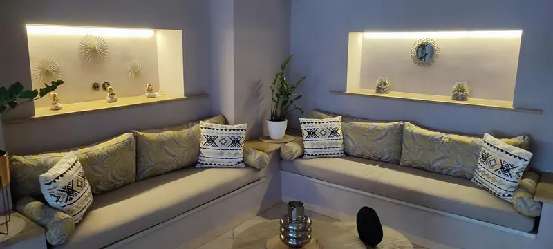 Coin salon avec banquettes et coussins décoratifs.
