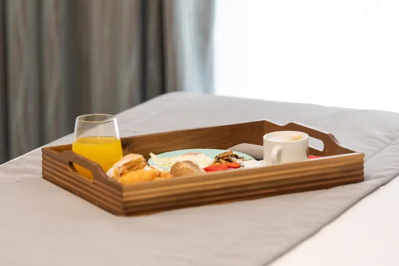 Un plateau de petit-déjeuner est posé sur un lit.