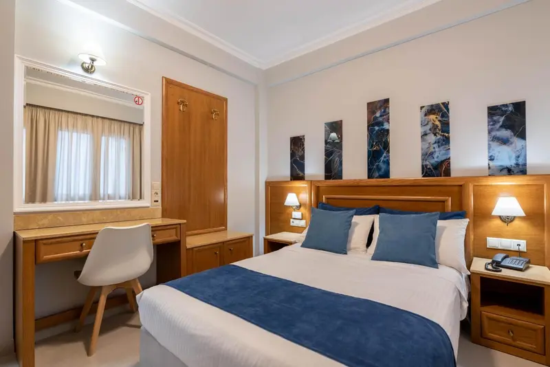 Une chambre d'hôtel avec un lit double et un bureau.