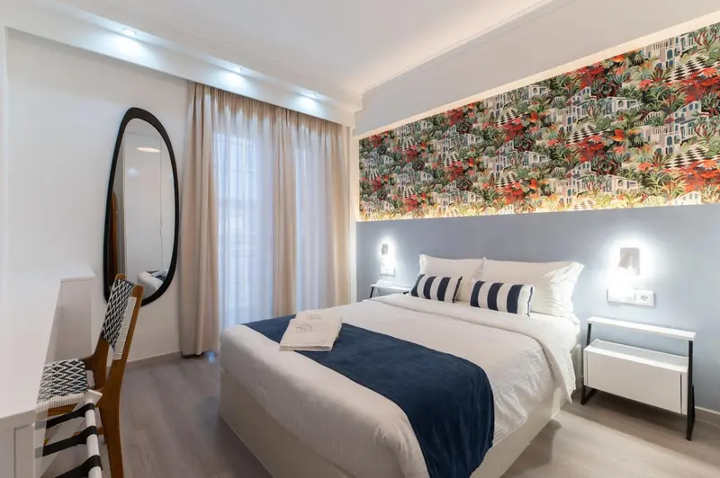 Une chambre lumineuse avec un grand lit et un mur décoré.