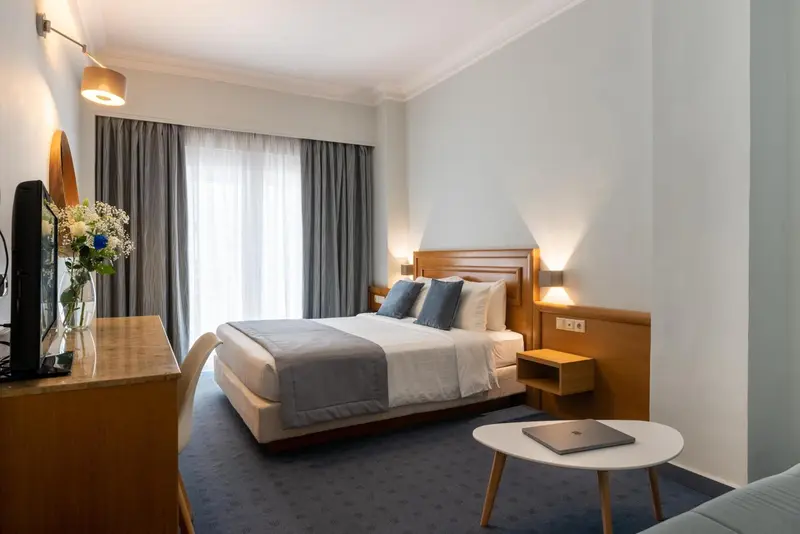 Une chambre lumineuse avec un grand lit et des meubles en bois.