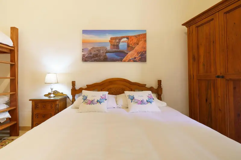 Une chambre lumineuse avec un grand lit et une décoration florale.