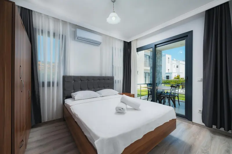 Une chambre lumineuse avec un grand lit et un accès à une terrasse.