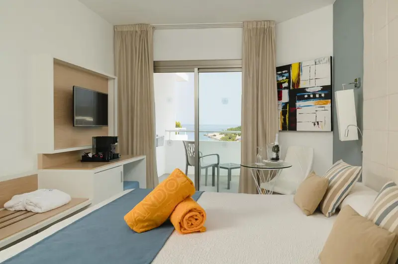 Une chambre lumineuse avec un lit et un accès à un balcon.