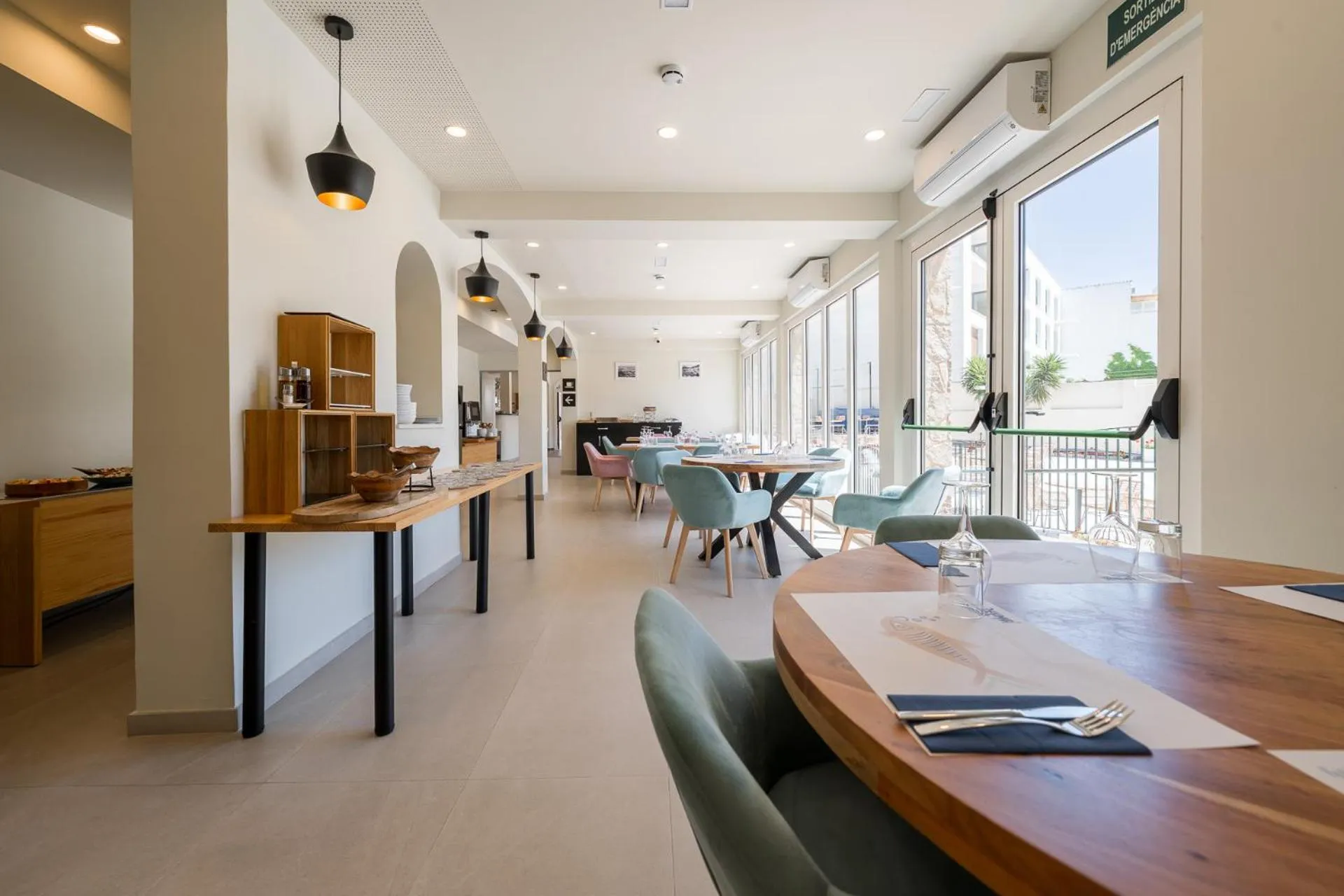 Une salle lumineuse avec des tables et des chaises pour les repas.