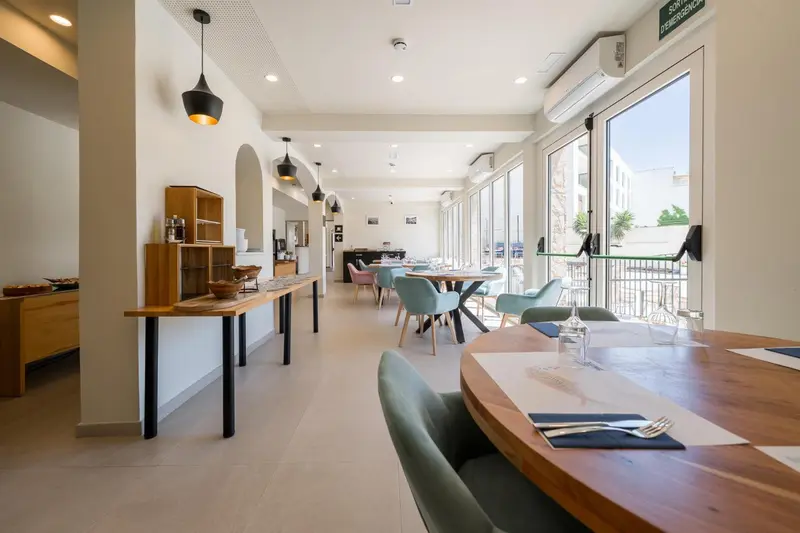 Une salle lumineuse avec des tables et des chaises pour les repas.