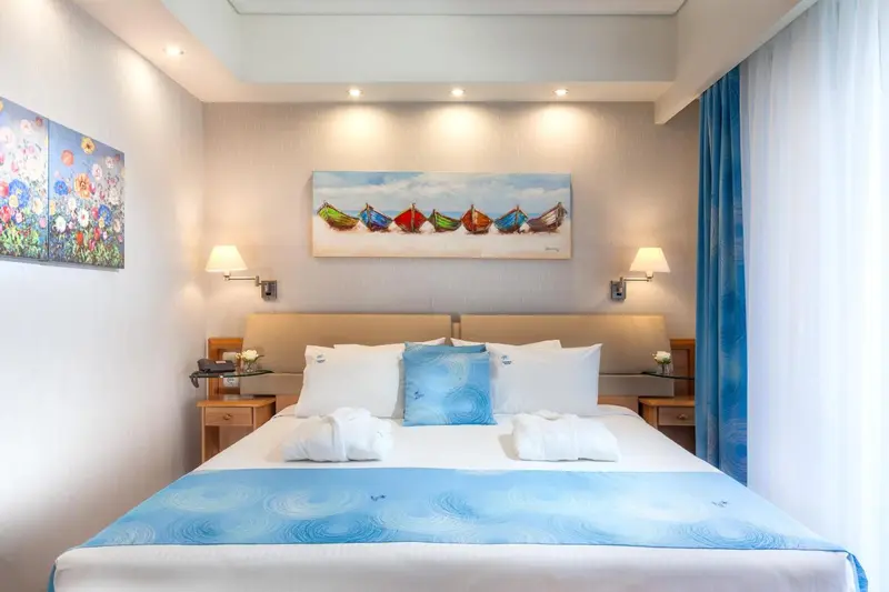 Une chambre lumineuse avec un grand lit et une décoration marine.