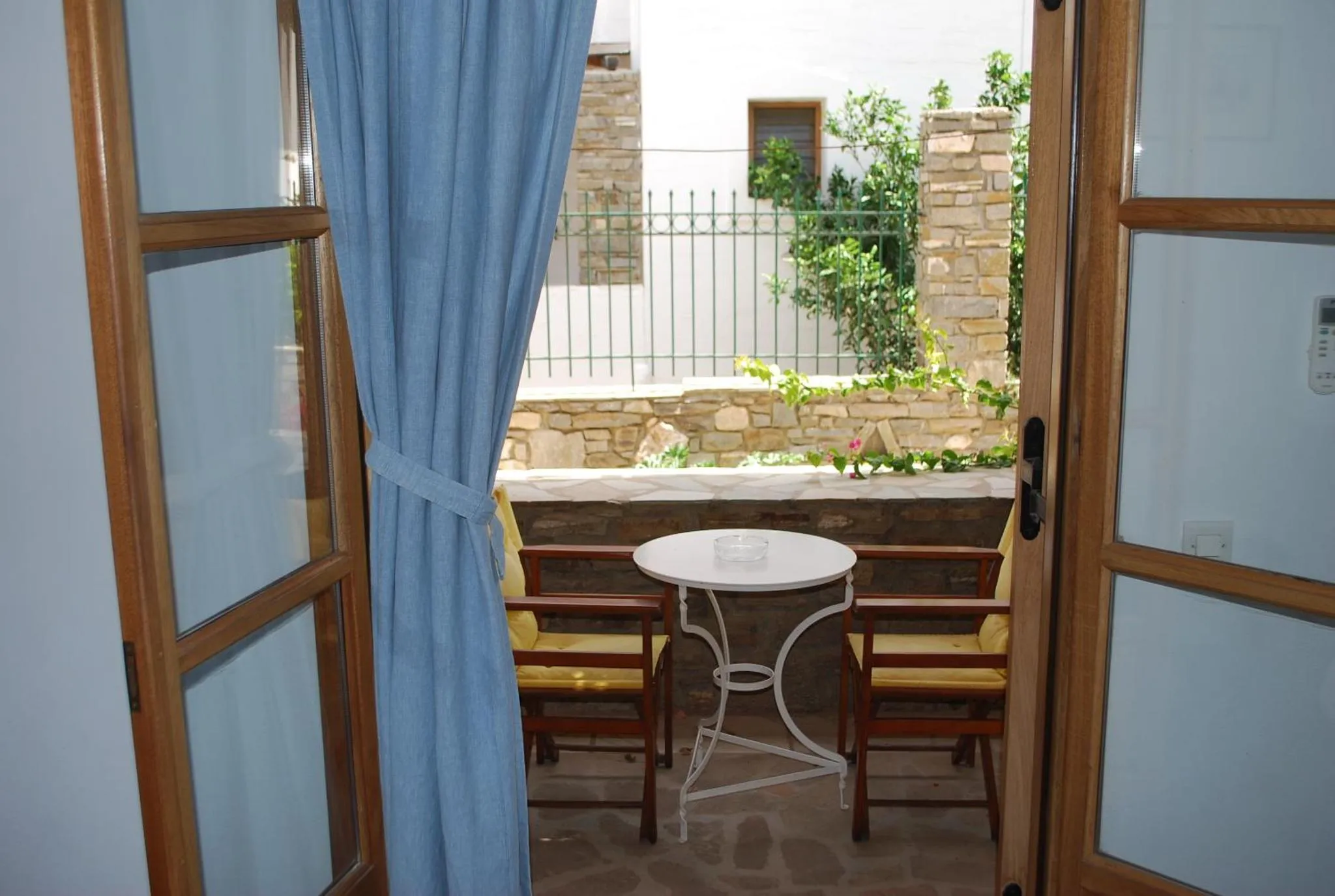 Une terrasse avec une table et des chaises en fer forgé offre un espace de détente extérieur.