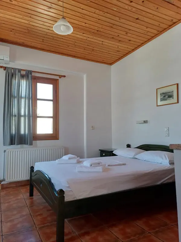 Une chambre lumineuse avec un lit recouvert d'une courtepointe blanche.