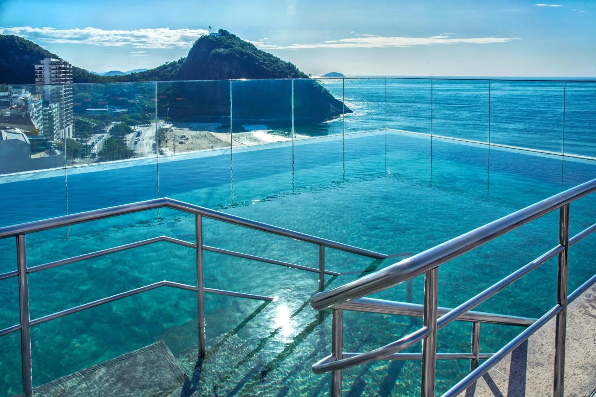 Vue sur la mer depuis une piscine à débordement avec un fond transparent.