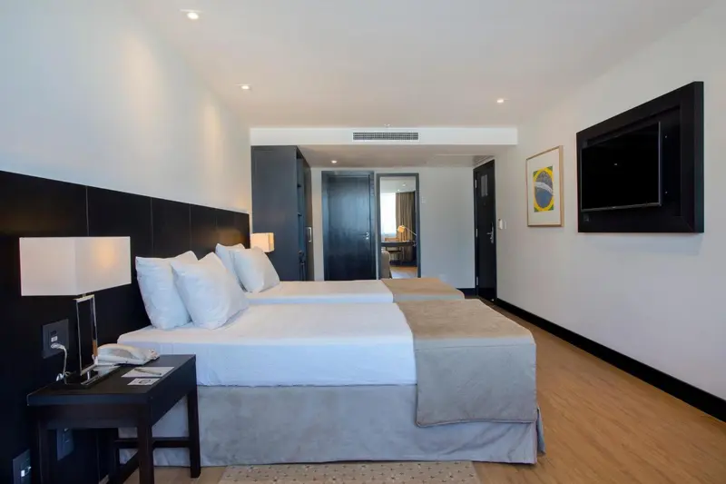 Une chambre lumineuse avec deux lits simples et une décoration sobre.