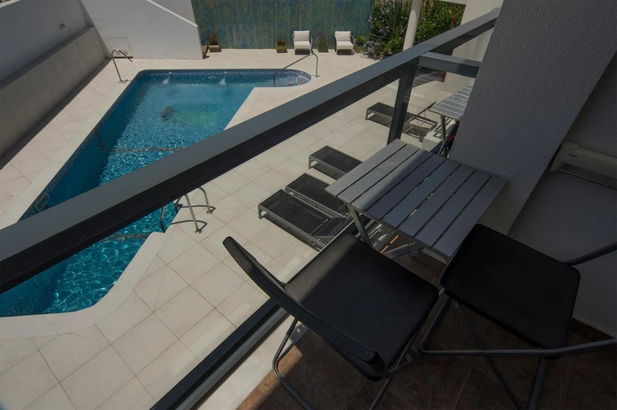 Terrasse avec mobilier d'extérieur donnant sur une piscine.