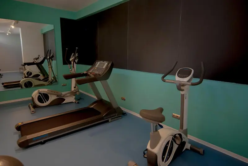 Une salle de sport lumineuse avec plusieurs appareils de fitness.