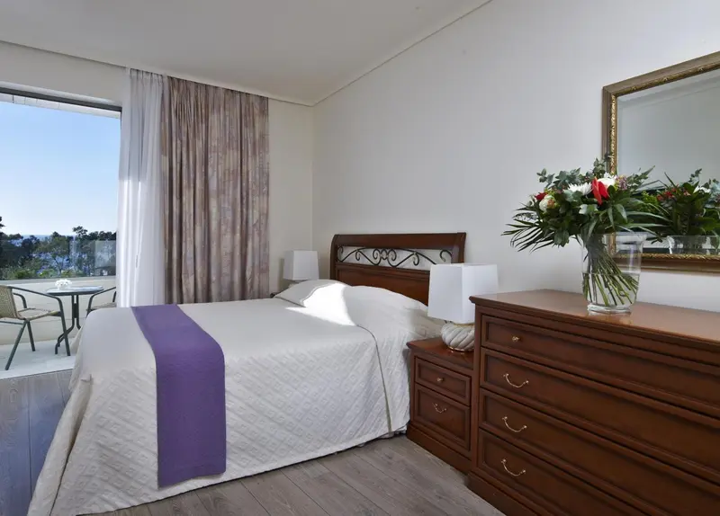 Une chambre lumineuse avec un grand lit et une vue sur l'extérieur.
