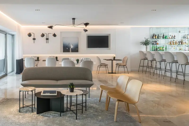 Un espace de détente avec canapés, fauteuils et un bar bien approvisionné.