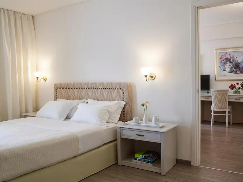 Une chambre lumineuse avec un grand lit et une décoration sobre.