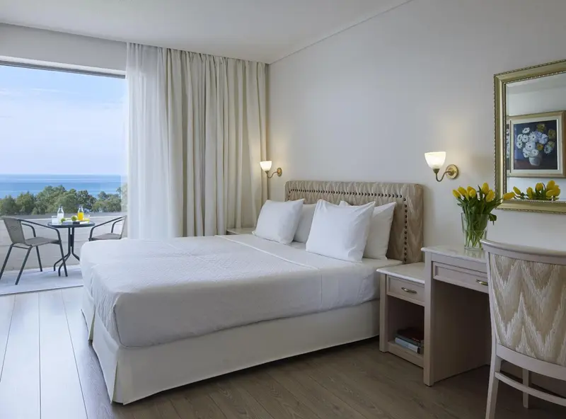 Une chambre lumineuse avec un grand lit et une vue sur la mer.