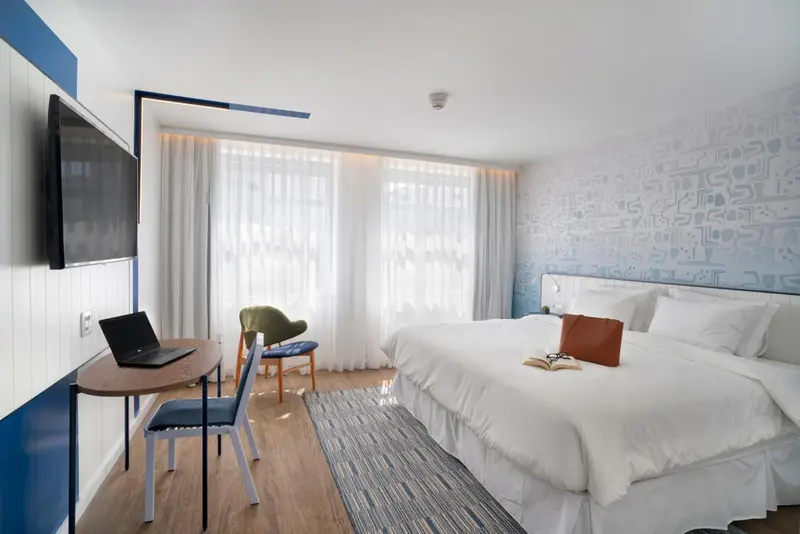 Une chambre lumineuse avec un grand lit et un espace de travail.