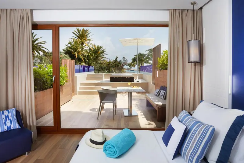 Une chambre lumineuse s'ouvre sur une terrasse avec coin repas.