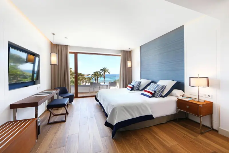 Une chambre lumineuse avec un grand lit et une vue sur la mer.