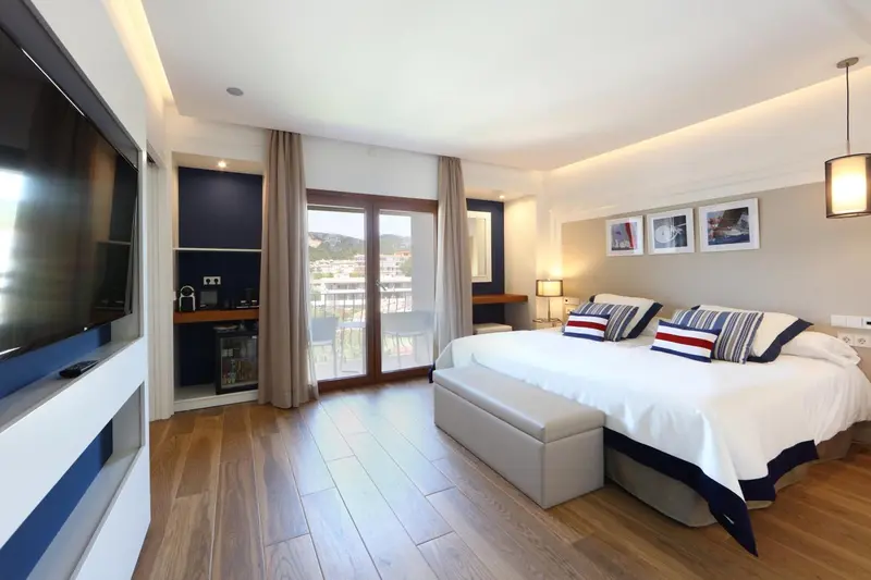Une chambre lumineuse avec un grand lit et un accès à un balcon.