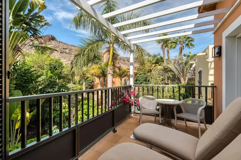 Terrasse avec mobilier de jardin et végétation luxuriante.