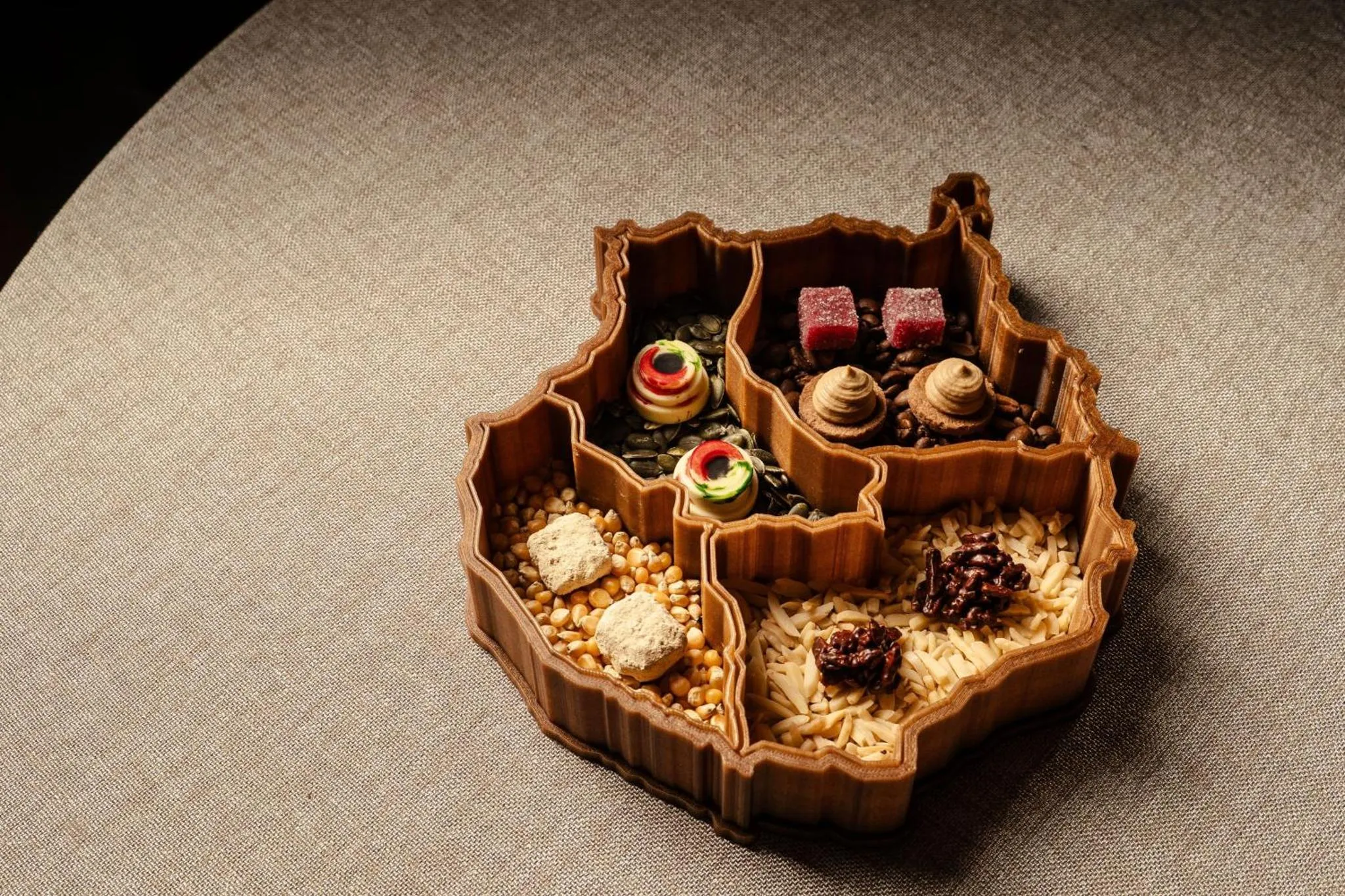 Assortiment de douceurs colorées disposées dans un plat compartimenté en bois.