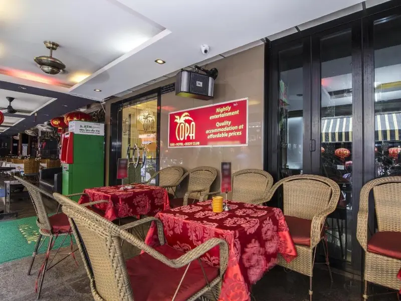 Terrasse de restaurant avec tables et chaises en osier.