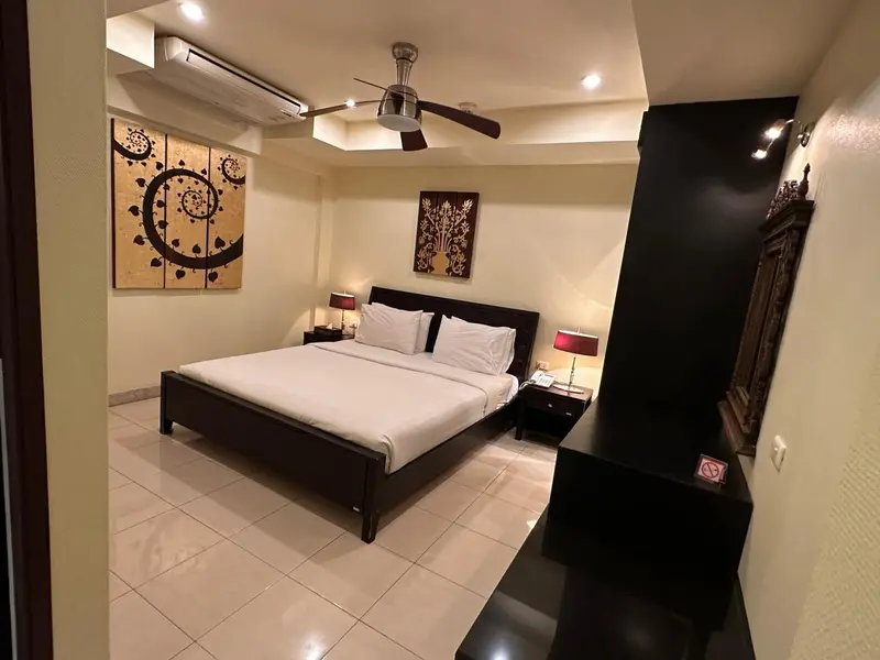 Une chambre lumineuse avec un grand lit et des tableaux décoratifs.