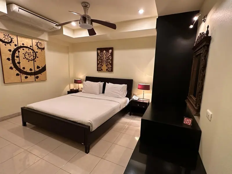 Une chambre lumineuse avec un grand lit et des tableaux décoratifs.