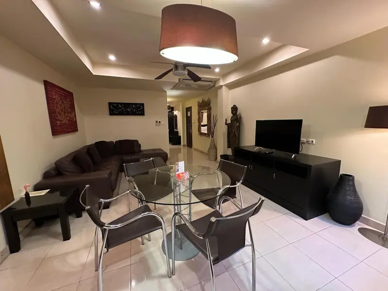 Un salon lumineux avec un coin repas et une décoration murale.