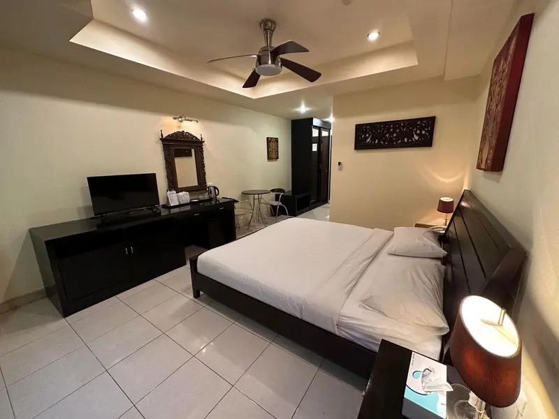 Une chambre spacieuse avec un grand lit et un meuble télévision.