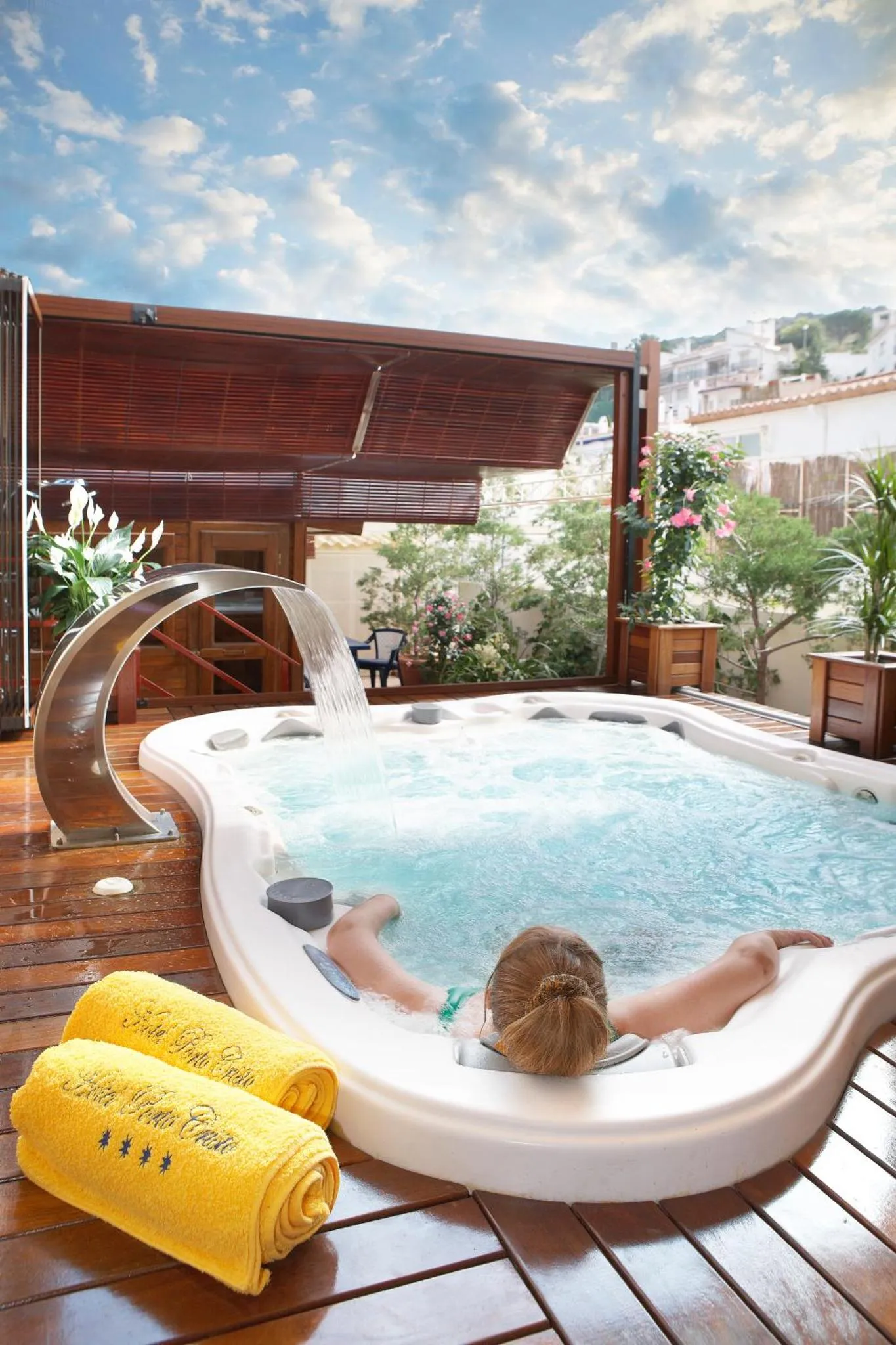 Une personne se détend dans un jacuzzi extérieur ensoleillé.