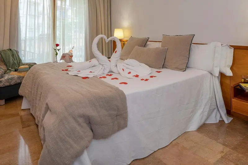Une chambre d'hotel avec un lit soigneusement fait et des decorations florales.