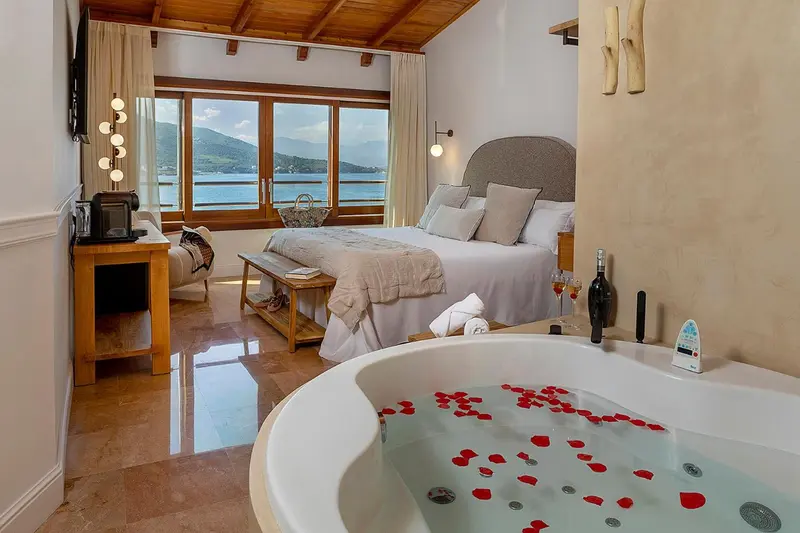 Une chambre lumineuse avec un grand lit et une baignoire à remous.