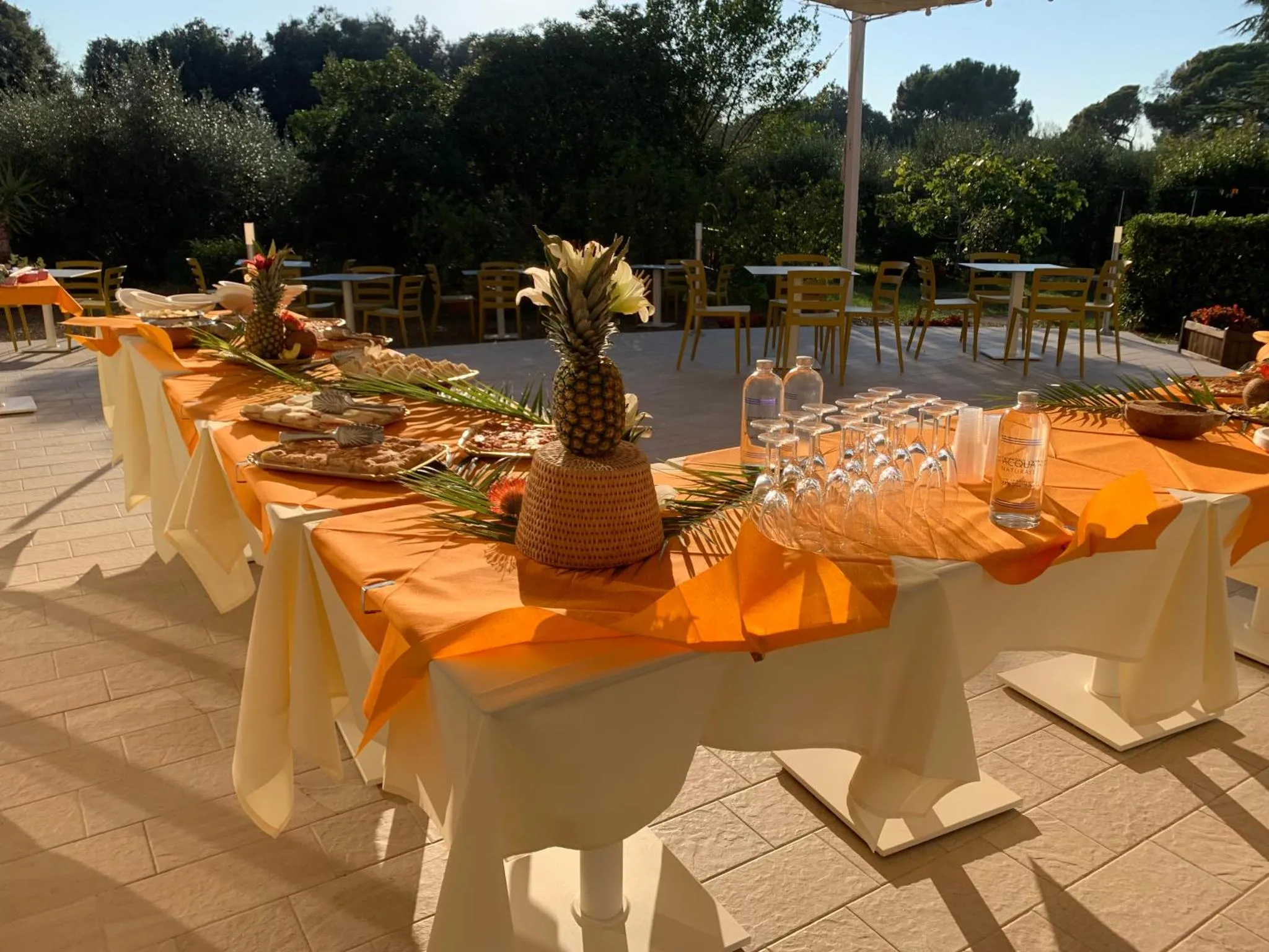 Une table dressée avec des plats et des boissons sur une terrasse ensoleillée.