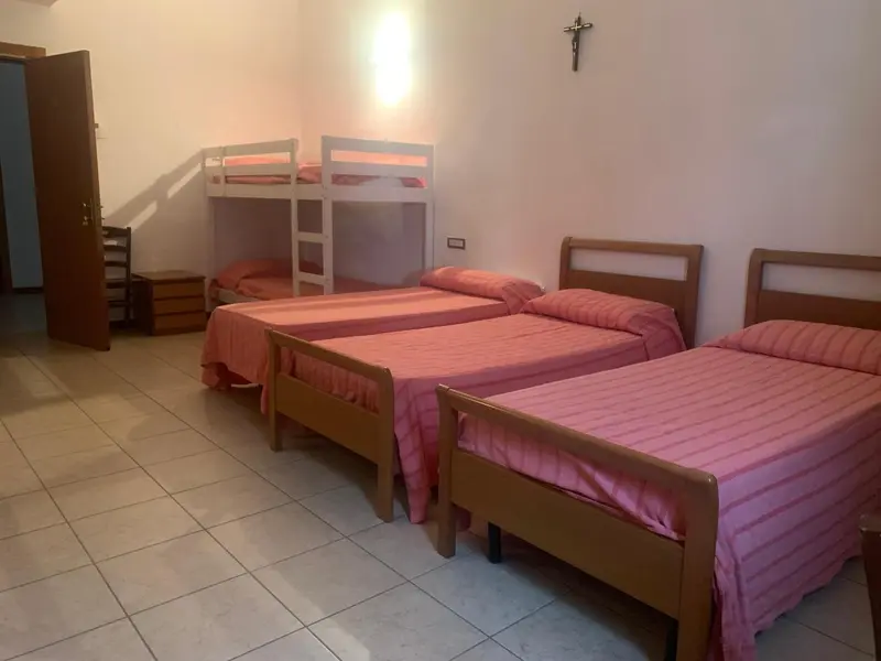 Une chambre avec des lits simples et un lit superposé.