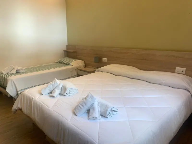 Une chambre avec deux lits simples décorés de serviettes.