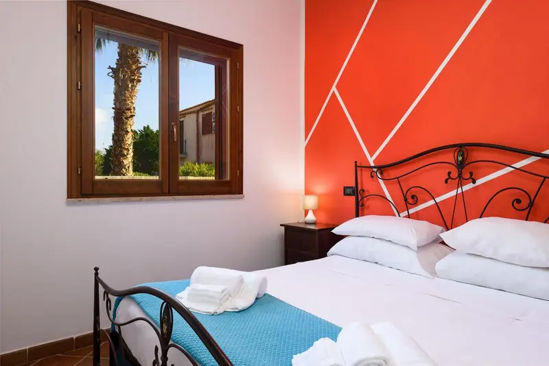Une chambre lumineuse avec un lit et une fenêtre donnant sur un paysage.