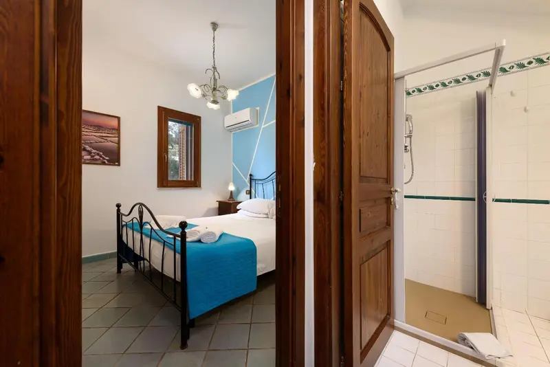 Une chambre lumineuse avec un lit et une salle de bain attenante.