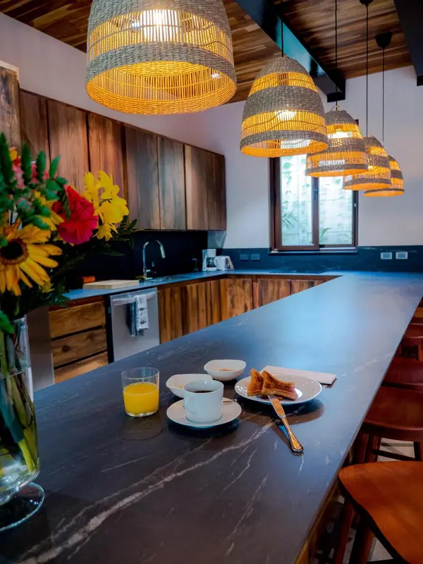 Un comptoir de bar en bois sombre présente un petit-déjeuner avec une boisson et une pâtisserie.